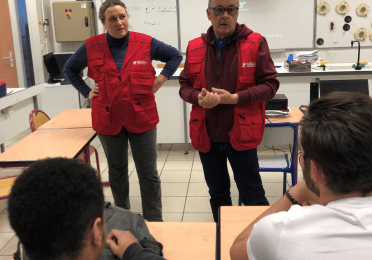 Two volunteers from Comité 64 raising awareness of students on the topic of road safety
